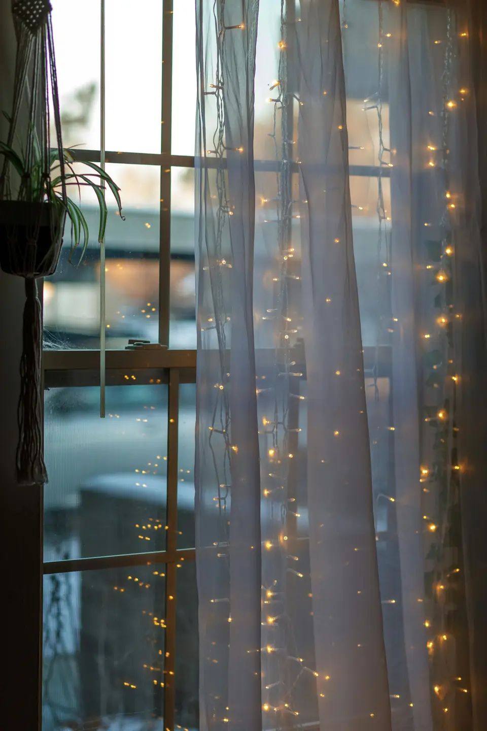 Fairy lights framing a window at dusk