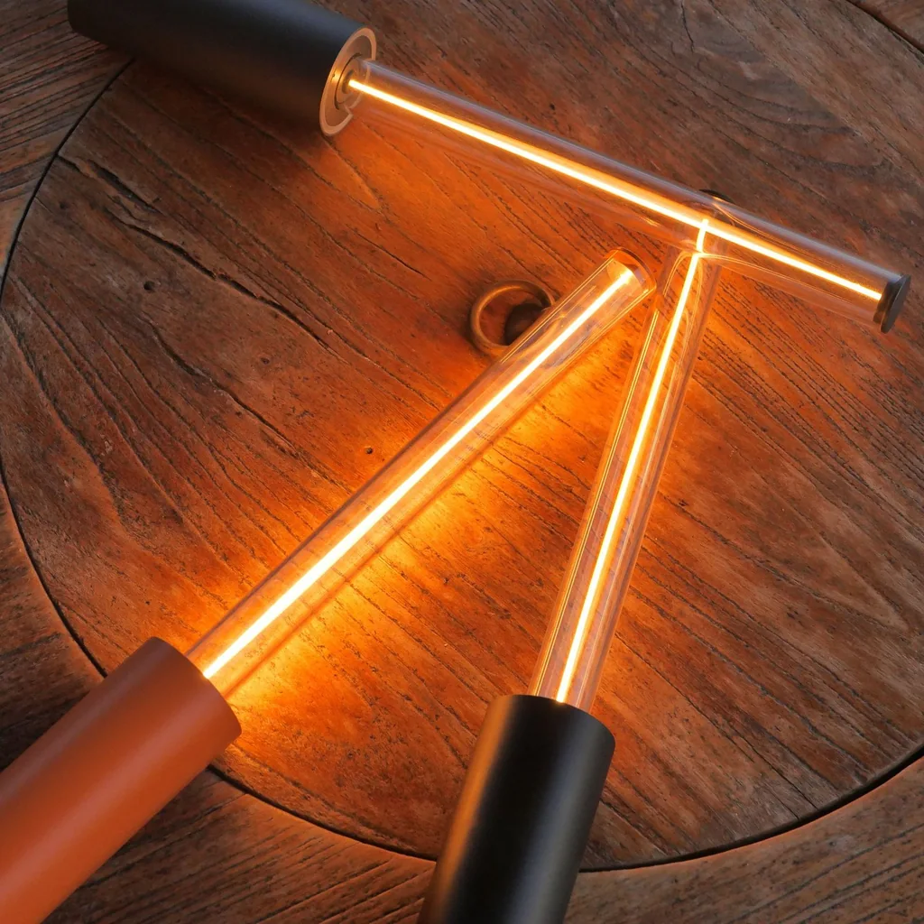 Two glow stick lamps lit, black and orange models (we sell black)